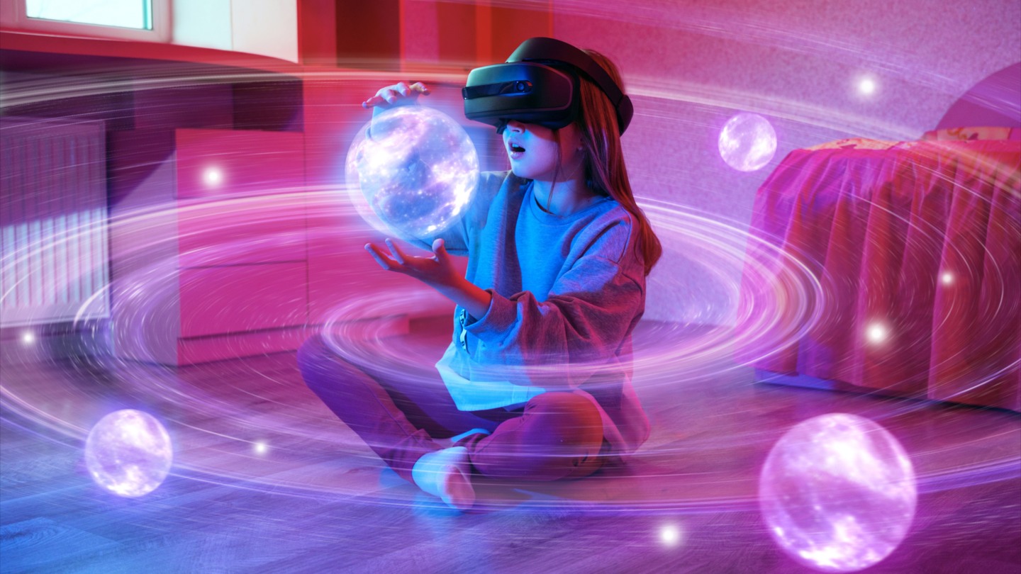 A child wearing a mixed-reality headset reaches toward glowing virtual objects
