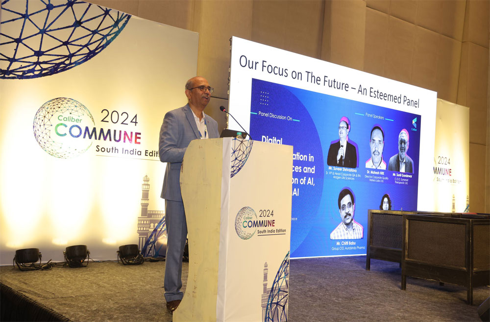 Sekhar Surabhi speaking at a lectern during Caliber Commune 2024 in Hyderabad