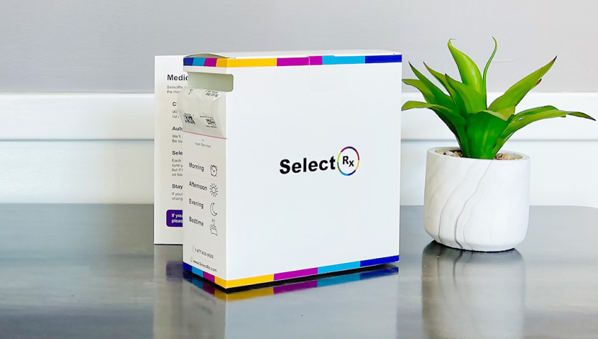 SelectRx medication box with a strip of packets marked by dosing time