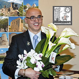 Giuseppe Ottaiano holding flowers in front of castle photographs