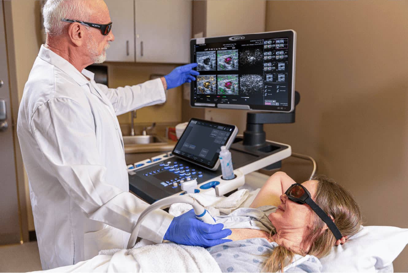 Clinician demonstrating an Imagio breast examination with ultrasound and color imaging on screen