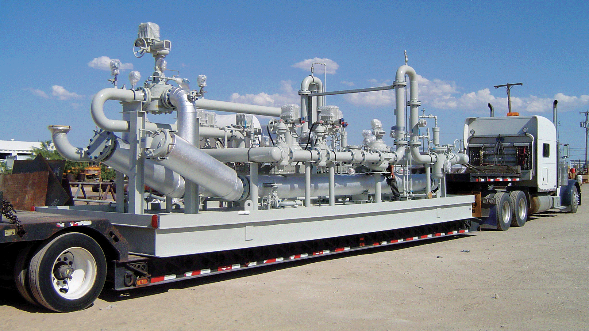Large integrated metering equipment secured to a flatbed trailer