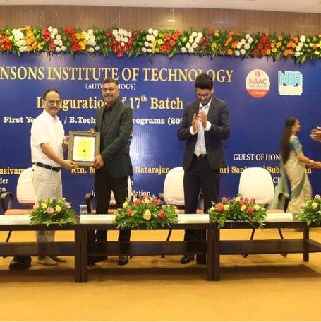Senthil Paramasivam receiving a framed memento on stage at Jansons Institute of Technology