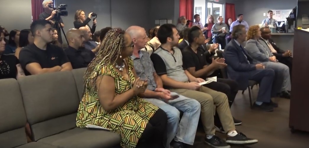 Audience members seated and applauding at a Sentinel day reporting center graduation