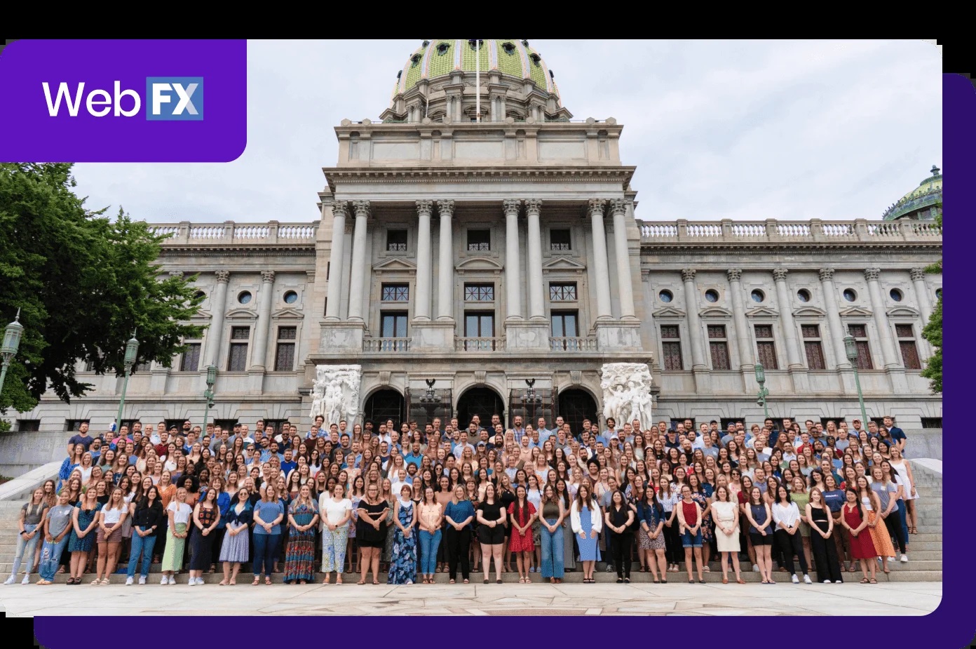 A large group of WebFX team members gathered outside a domed capitol building