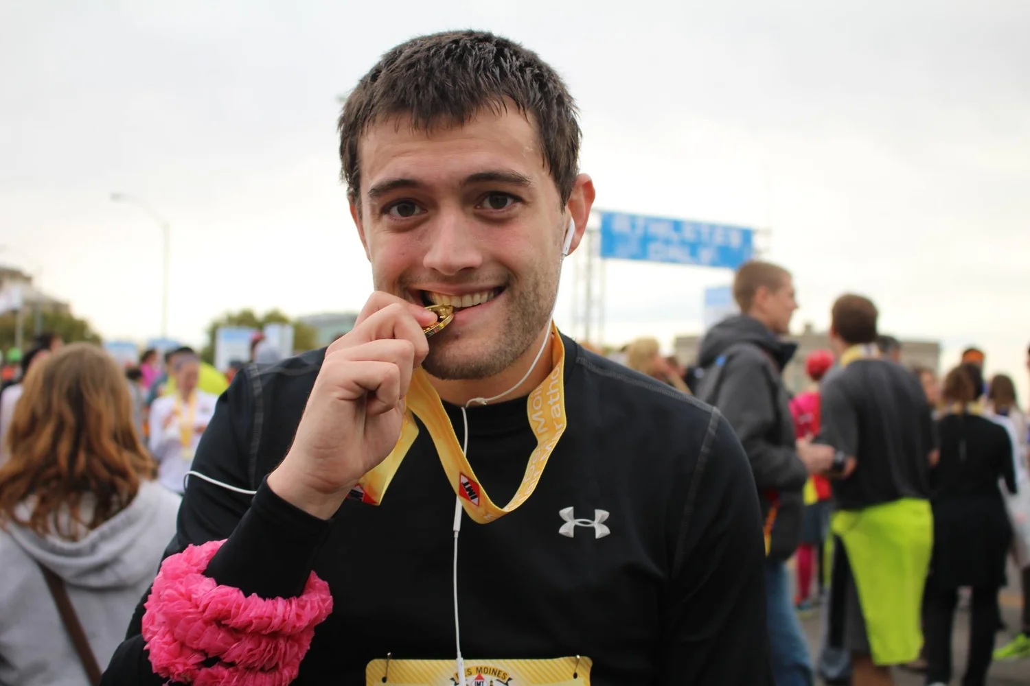 Dan Kurns smiling and holding a race medal to his teeth