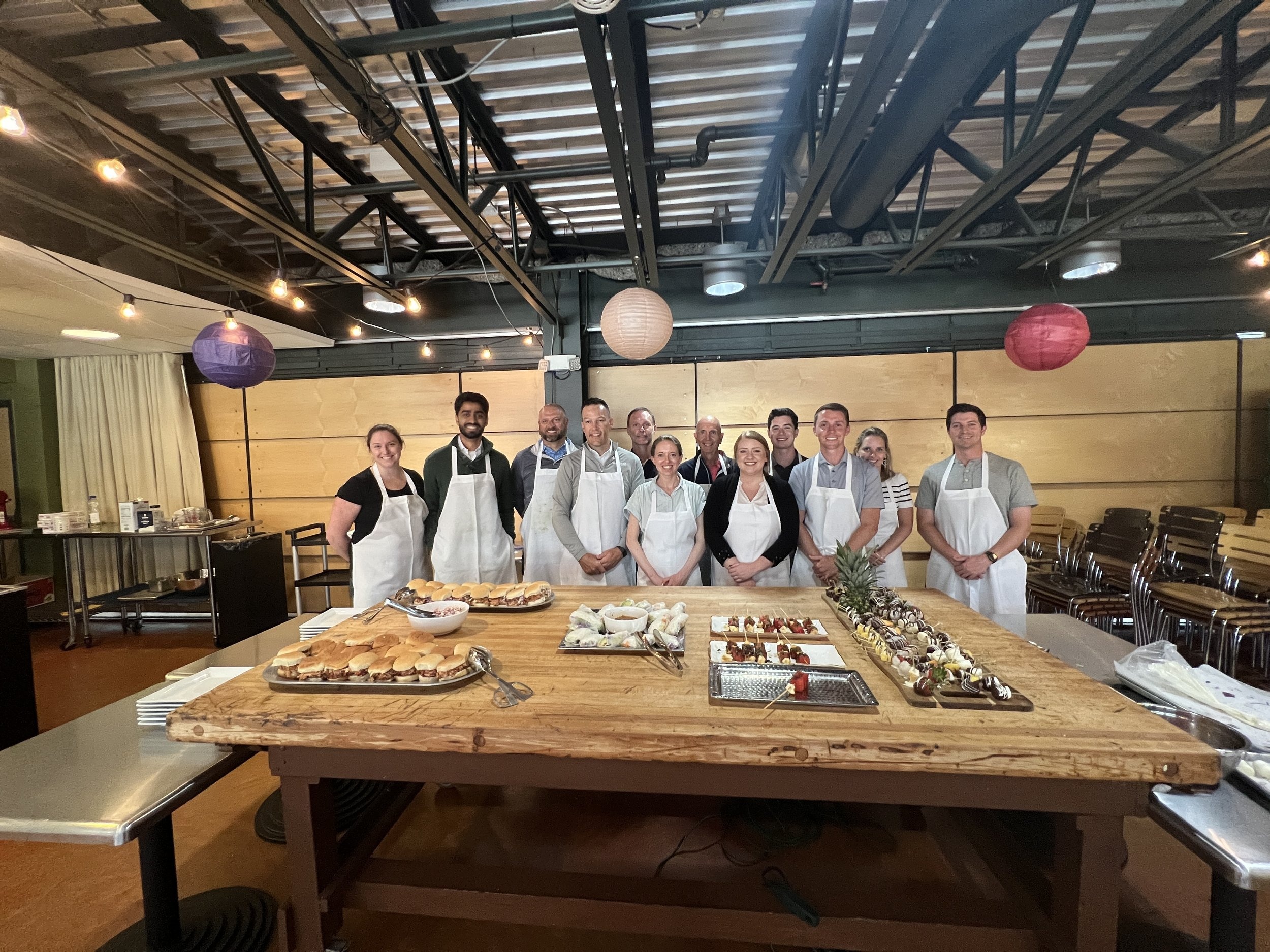 Sequoya Borgman and colleagues wearing aprons behind a table of food at Milwaukee Public Market