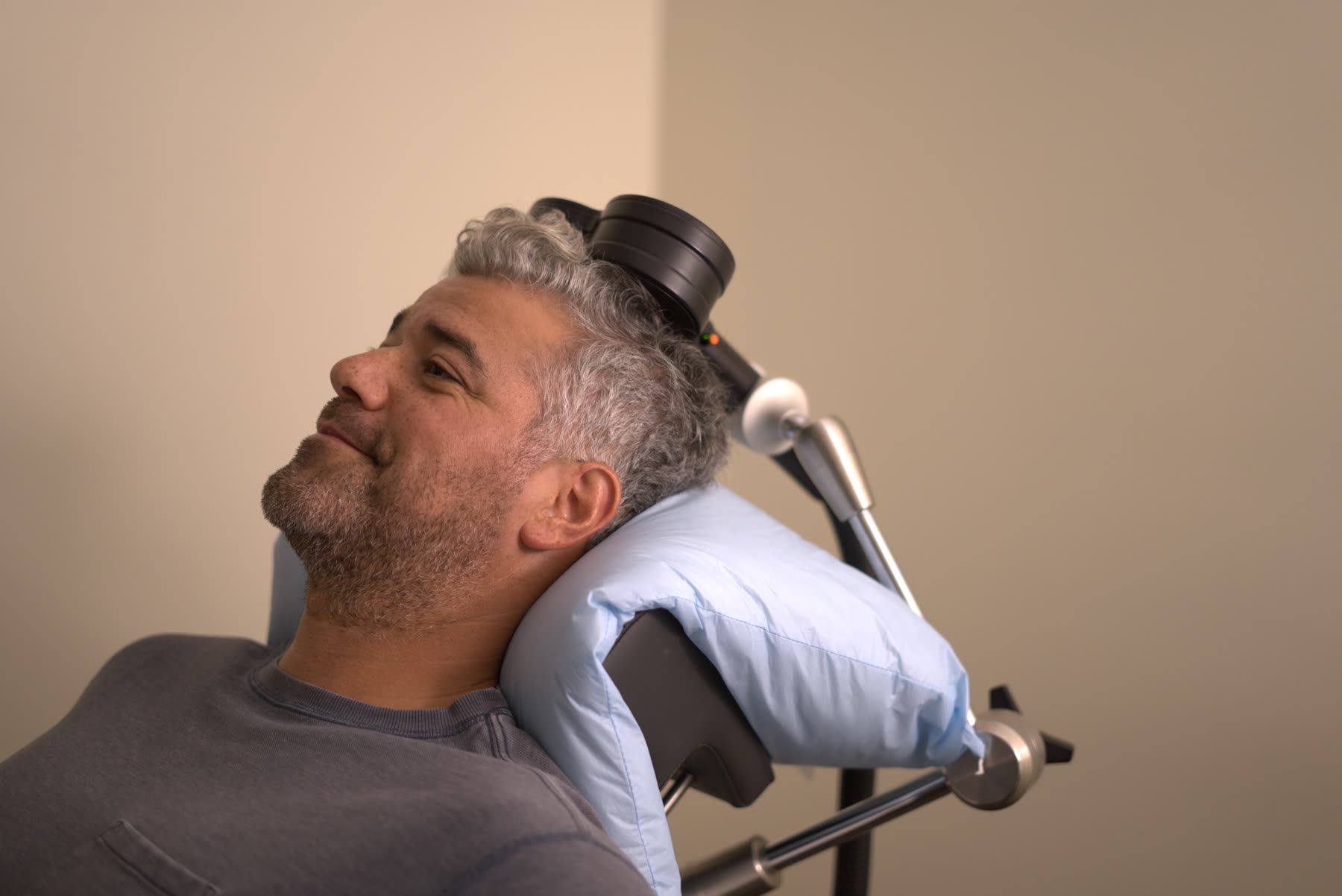 A person reclining beneath a magnetic stimulation treatment device in a photograph published by Serene Health Group