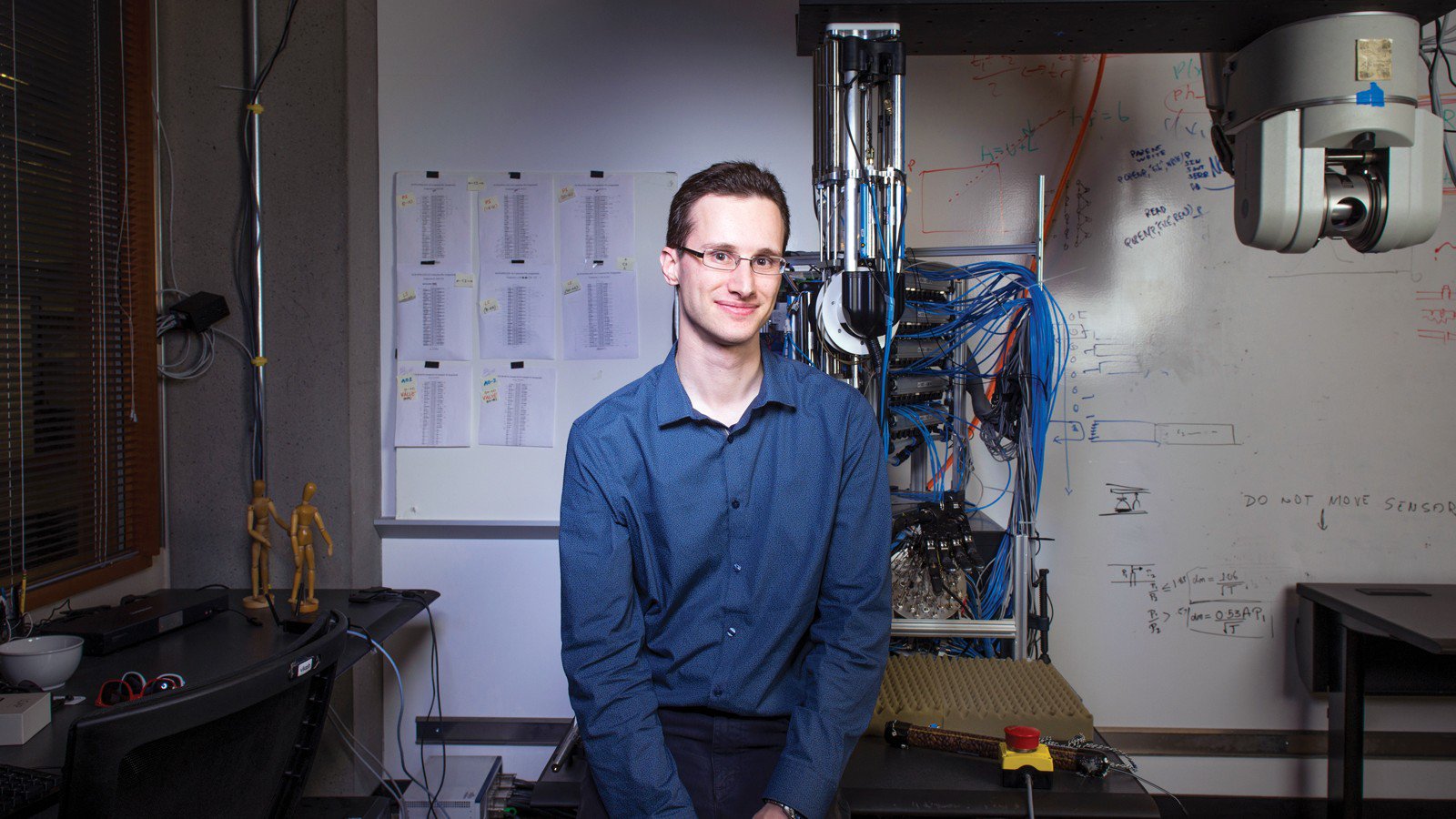Sergey Levine in a Berkeley robotics laboratory beside a robotic apparatus