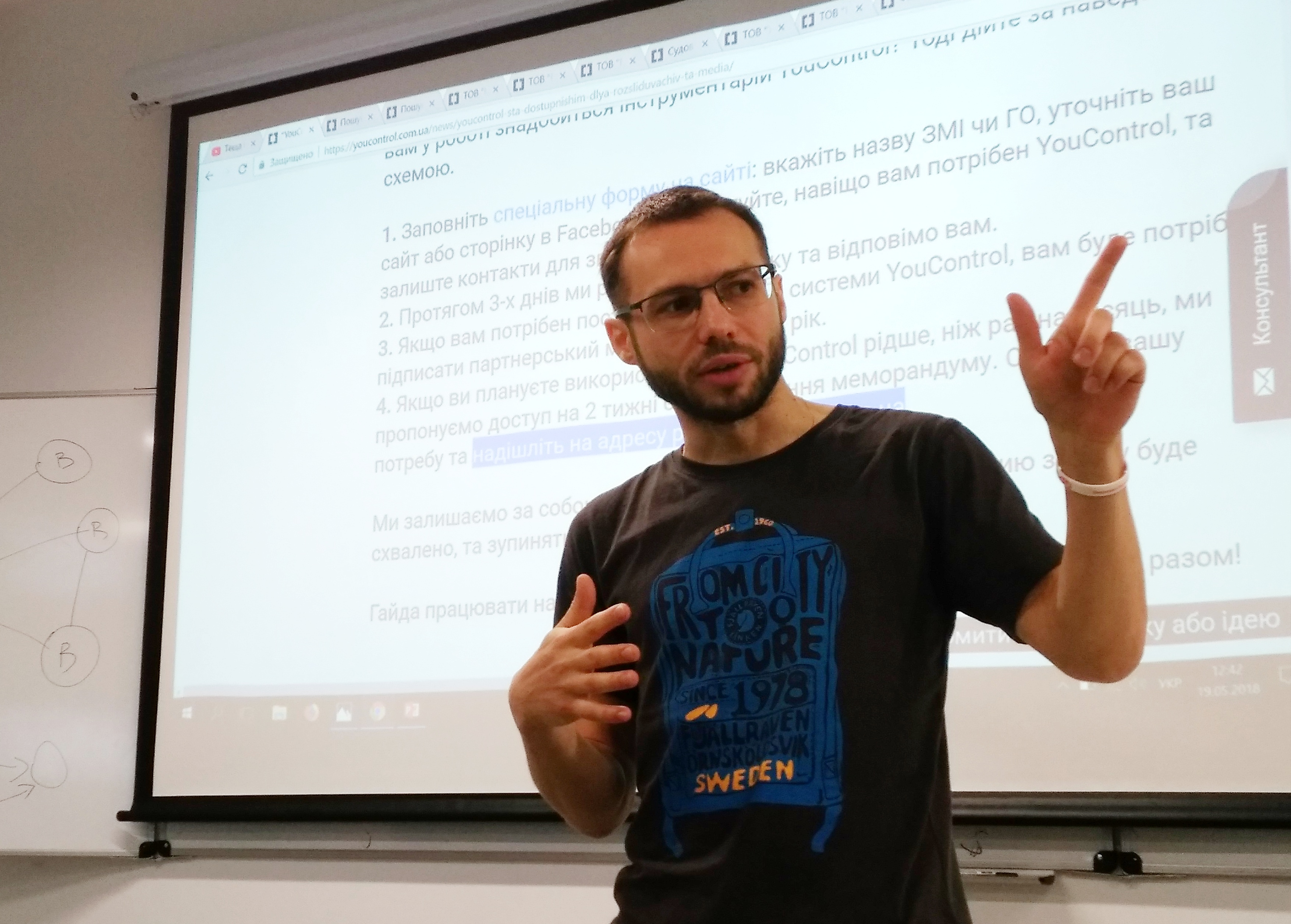 Sergiy Milman explaining YouControl in front of a projected presentation