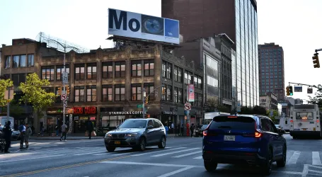 A Serino Coyne MoMA billboard above a New York street