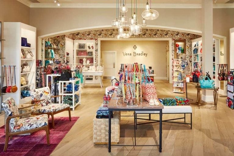 A Vera Bradley store with patterned bags arranged on shelves and tables