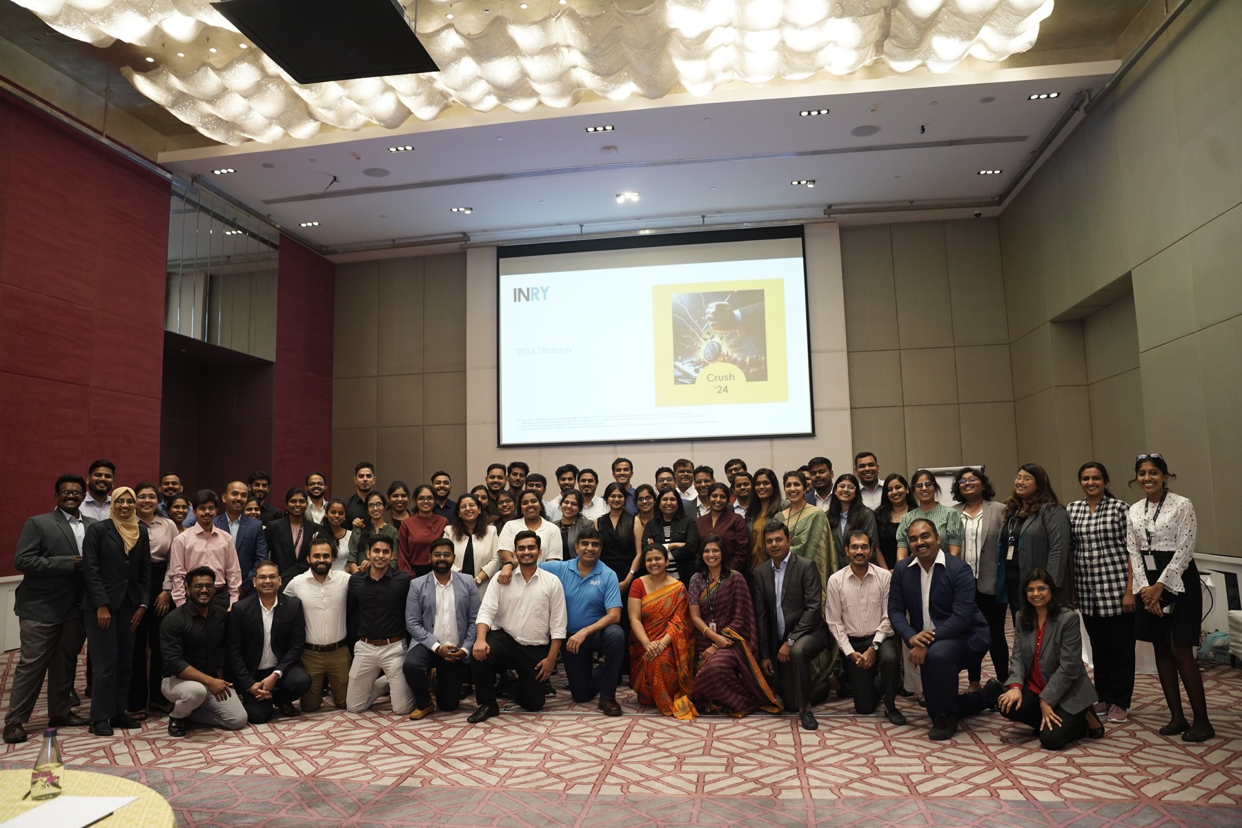 INRY’s team in a company photograph; the screen references its 2024 strategy. This is background imagery, not the 2026 rollout.