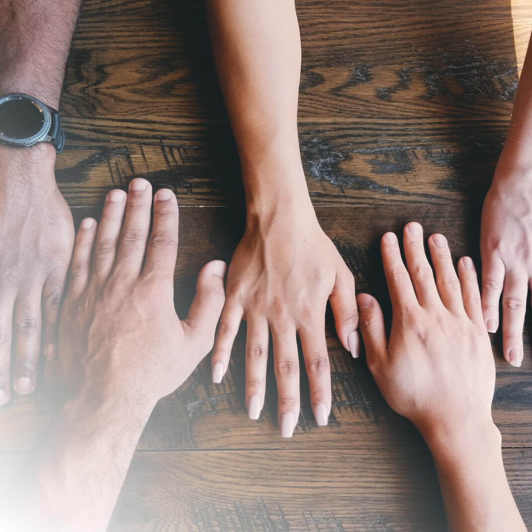 A group of hands gathered around a table
