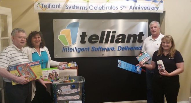 Seth Narayanan, at left, and colleagues holding games beneath a Telliant fifth-anniversary banner