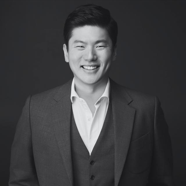 Seungjoon Lee, CEO and co-founder of AMAZE, smiling in a dark suit