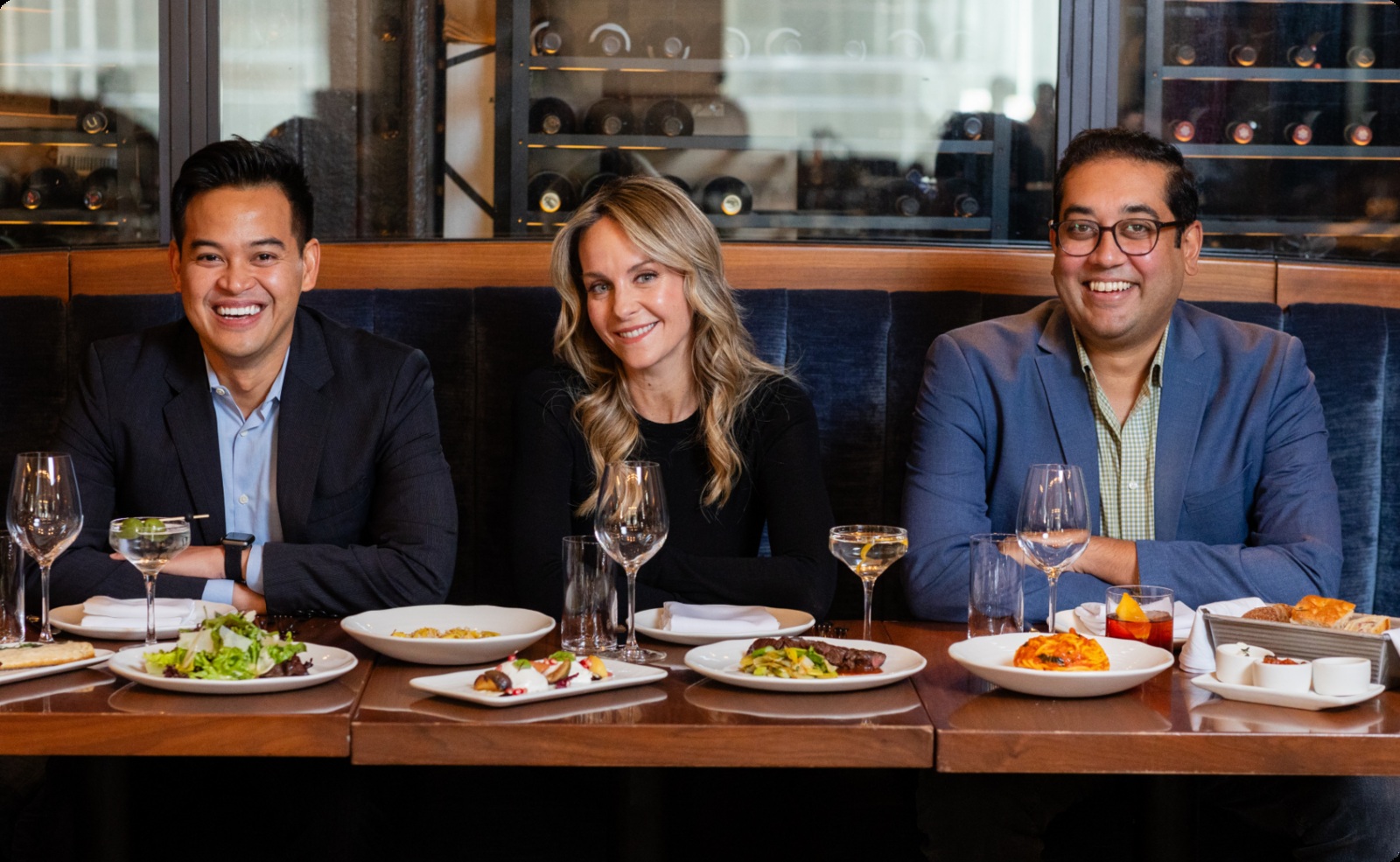 SevenRooms co-founders Joel Montaniel, Allison Page and Kinesh Patel seated together at a restaurant