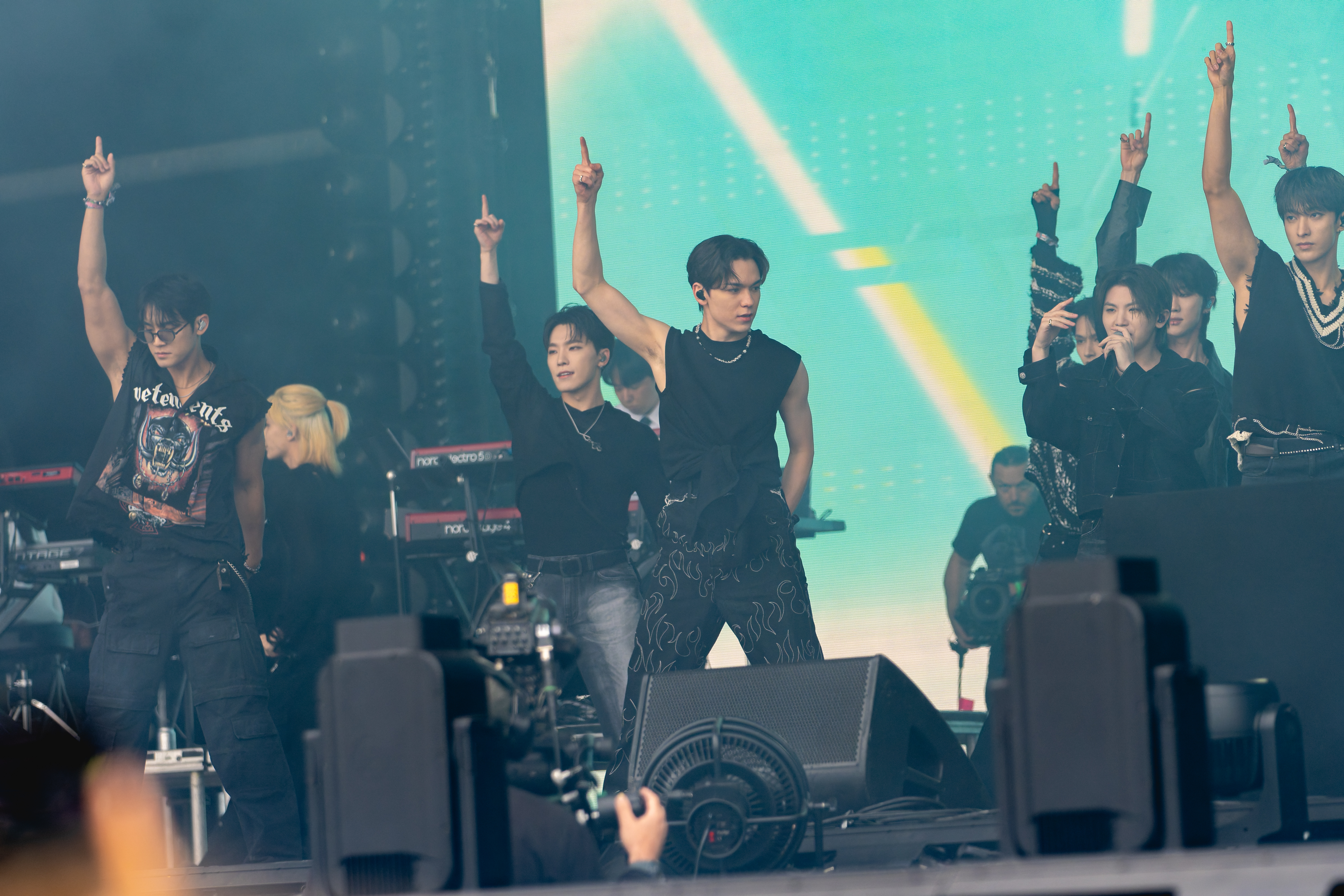 Members of SEVENTEEN performing in black stagewear at Glastonbury Festival in 2024