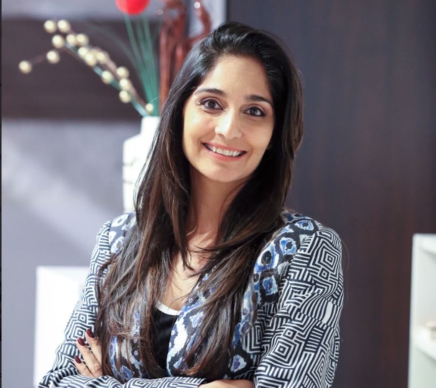 Shagufta Anurag seated in a patterned armchair in a Saltmine press photograph
