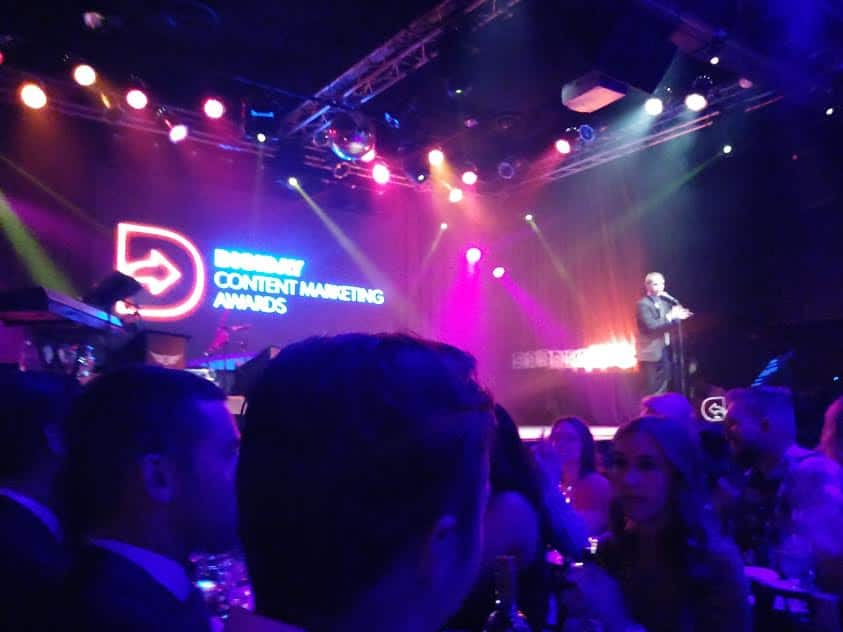 Colored stage lights and a seated audience at the Digiday Content Marketing Awards