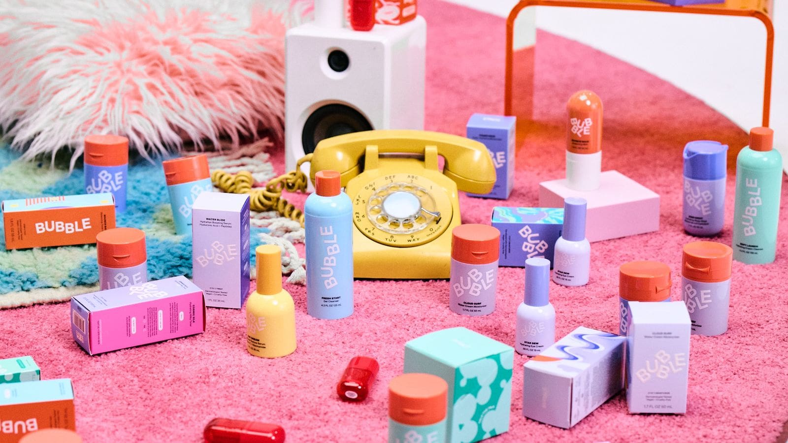 Colorful Bubble bottles and boxes arranged around a yellow rotary telephone