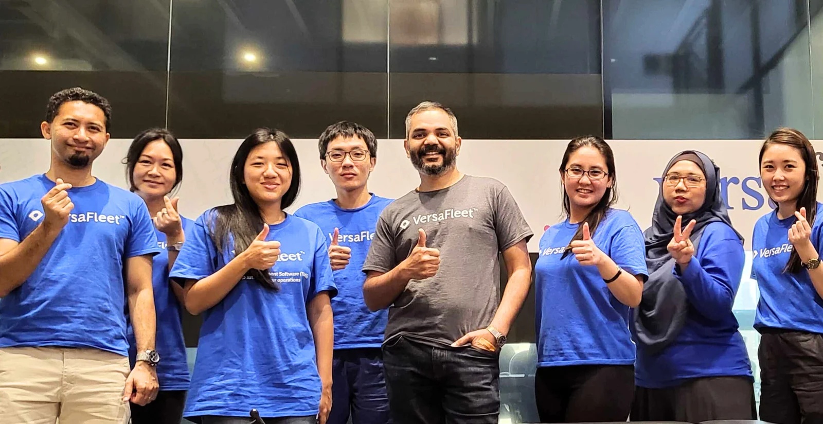 Members of the VersaFleet team pose together in company T-shirts