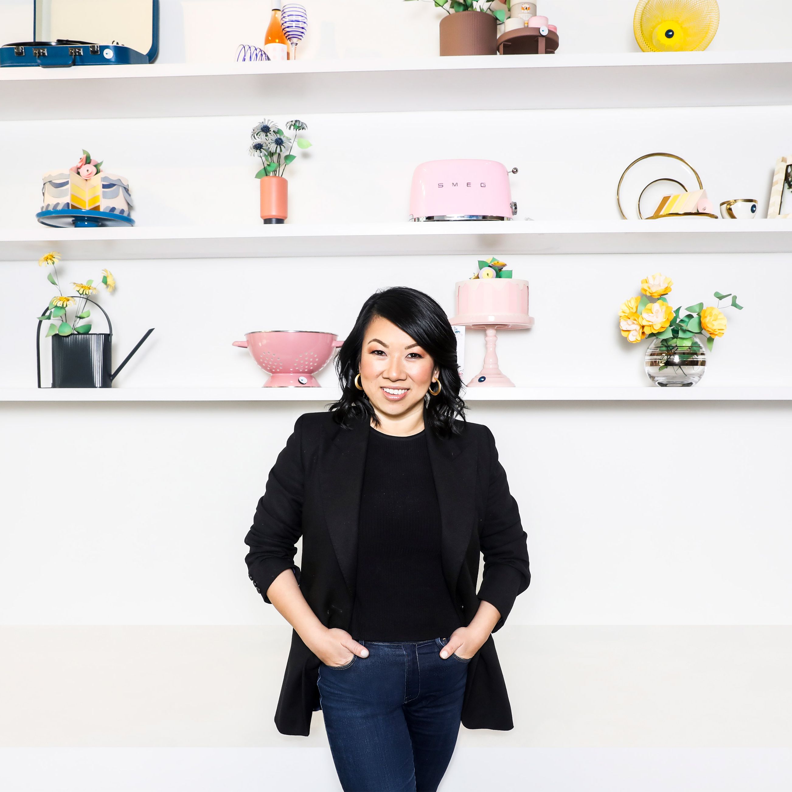Shan-Lyn Ma standing in Zola’s showroom beside shelves of colorful household gifts