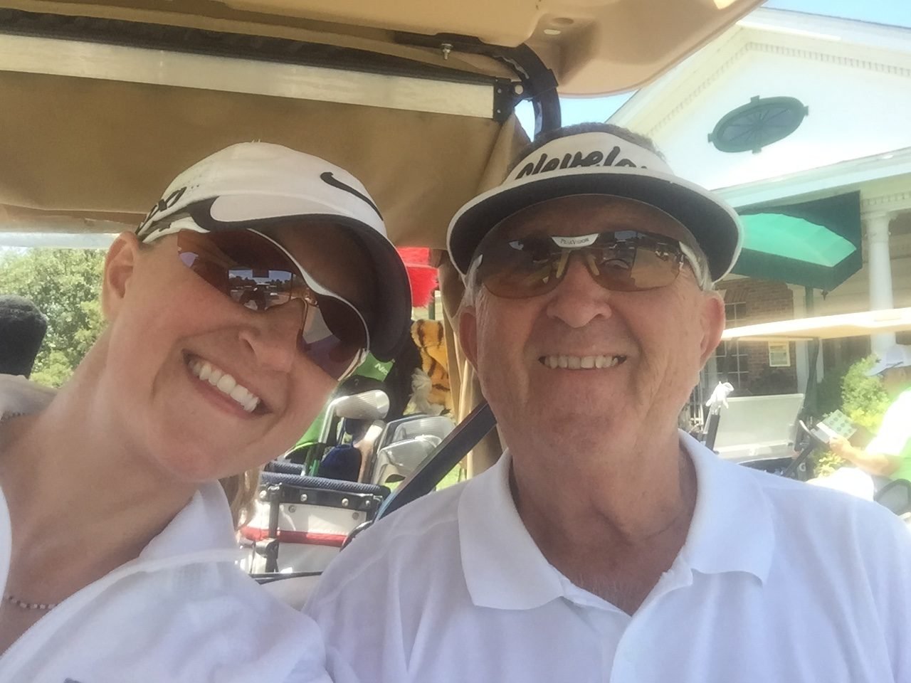 Sharon Tallach Vogelpohl and her father Edward Jerry Tallach smiling in a golf cart