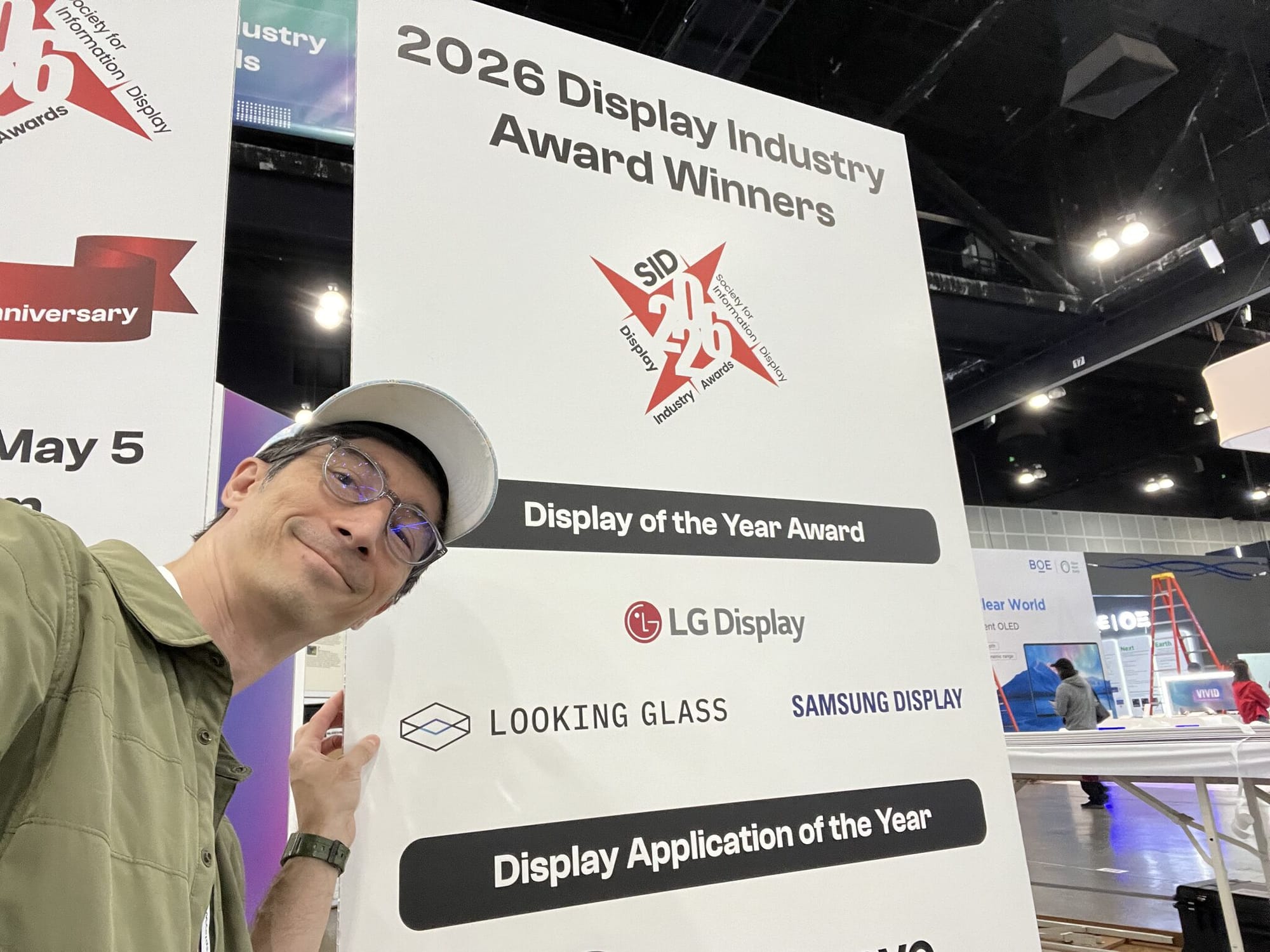 Shawn Frayne posing beside the 2026 Display Industry Award Winners sign bearing Looking Glass’s name