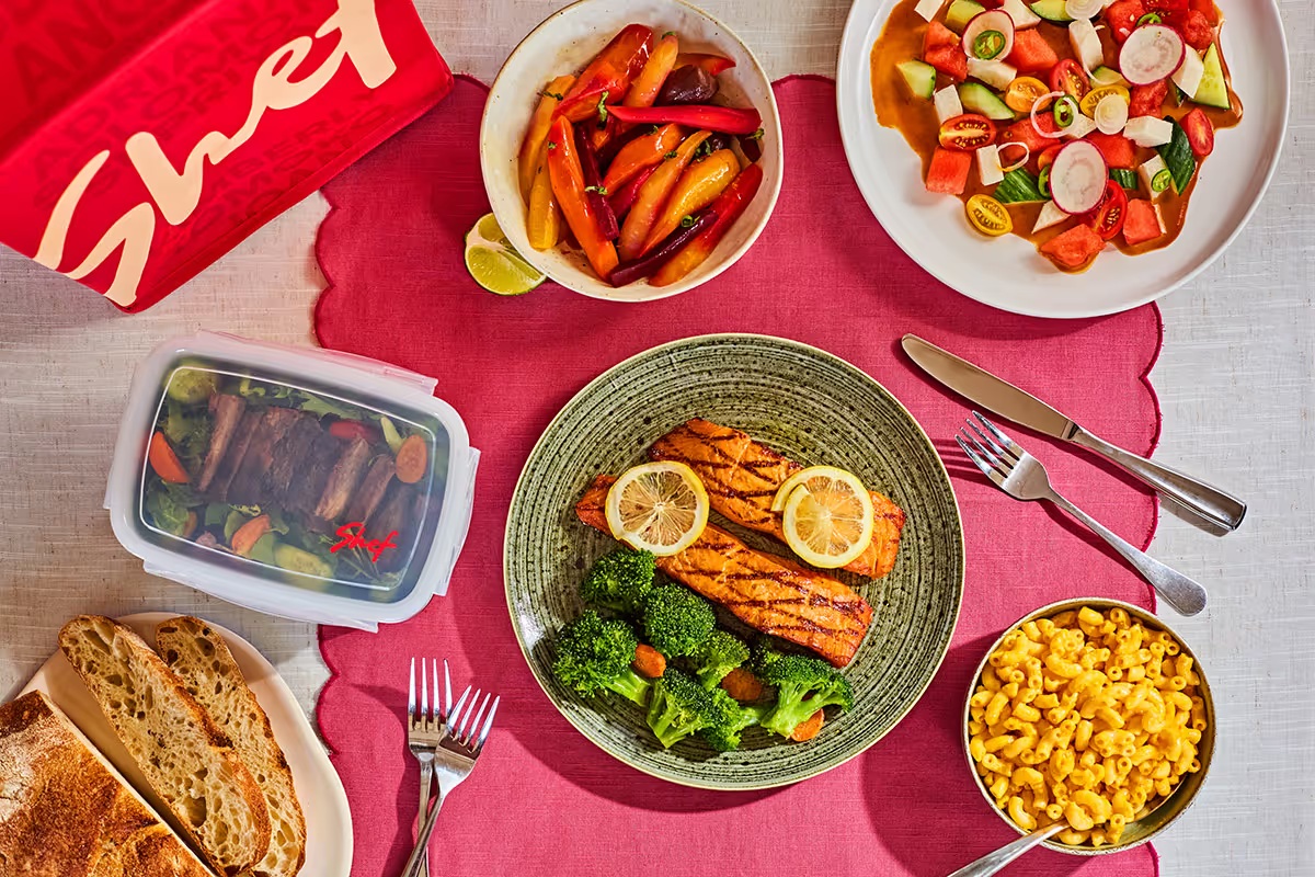 Shef meal spread with salmon, broccoli, vegetables, salad, bread and macaroni and cheese.