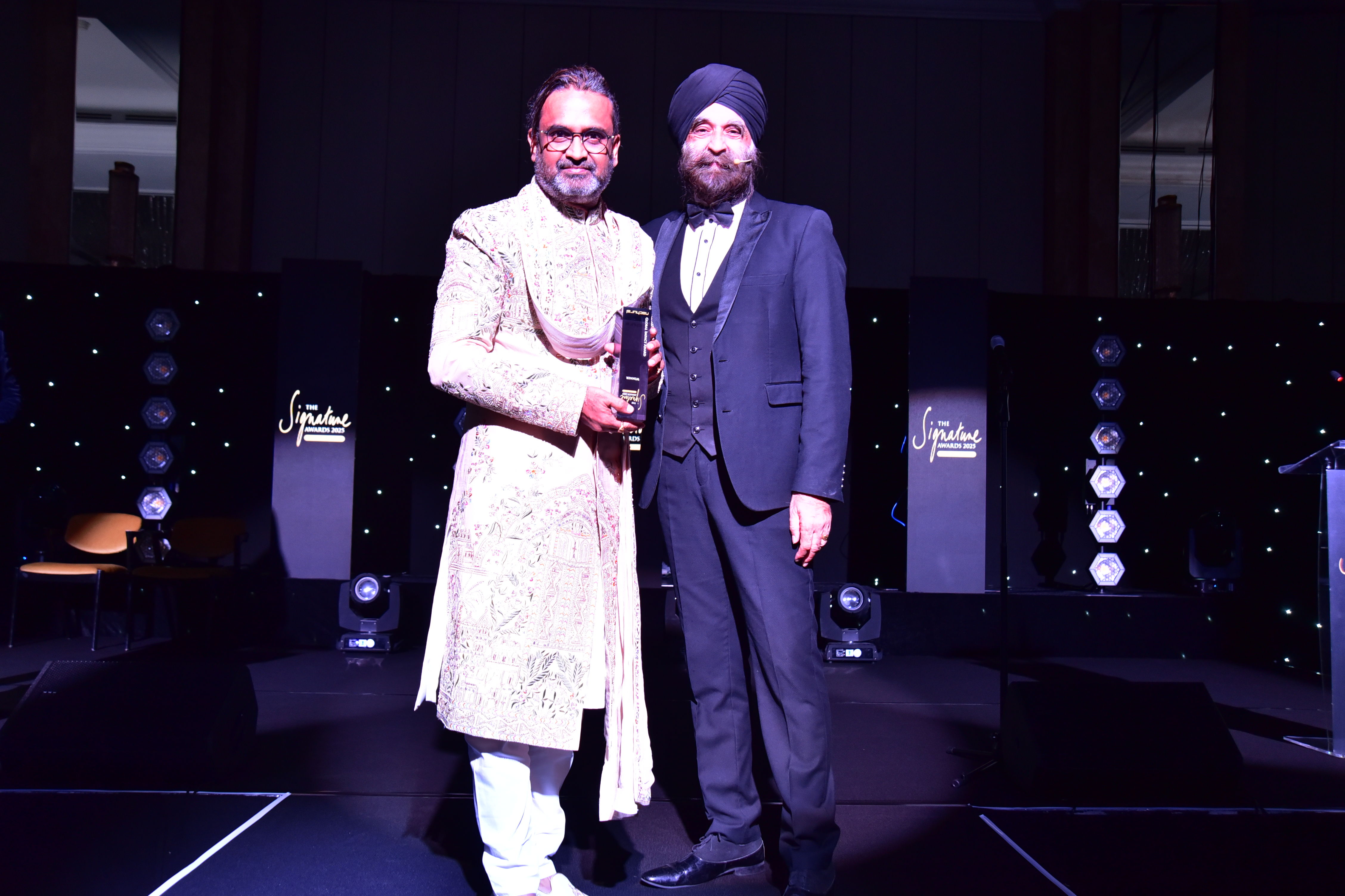 Shekar Natarajan, left, holding an award beside another attendee at the 2025 Signature Awards