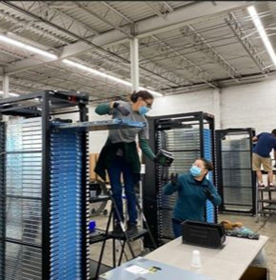 Sprout staff removing parts from equipment racks inside a North Carolina facility