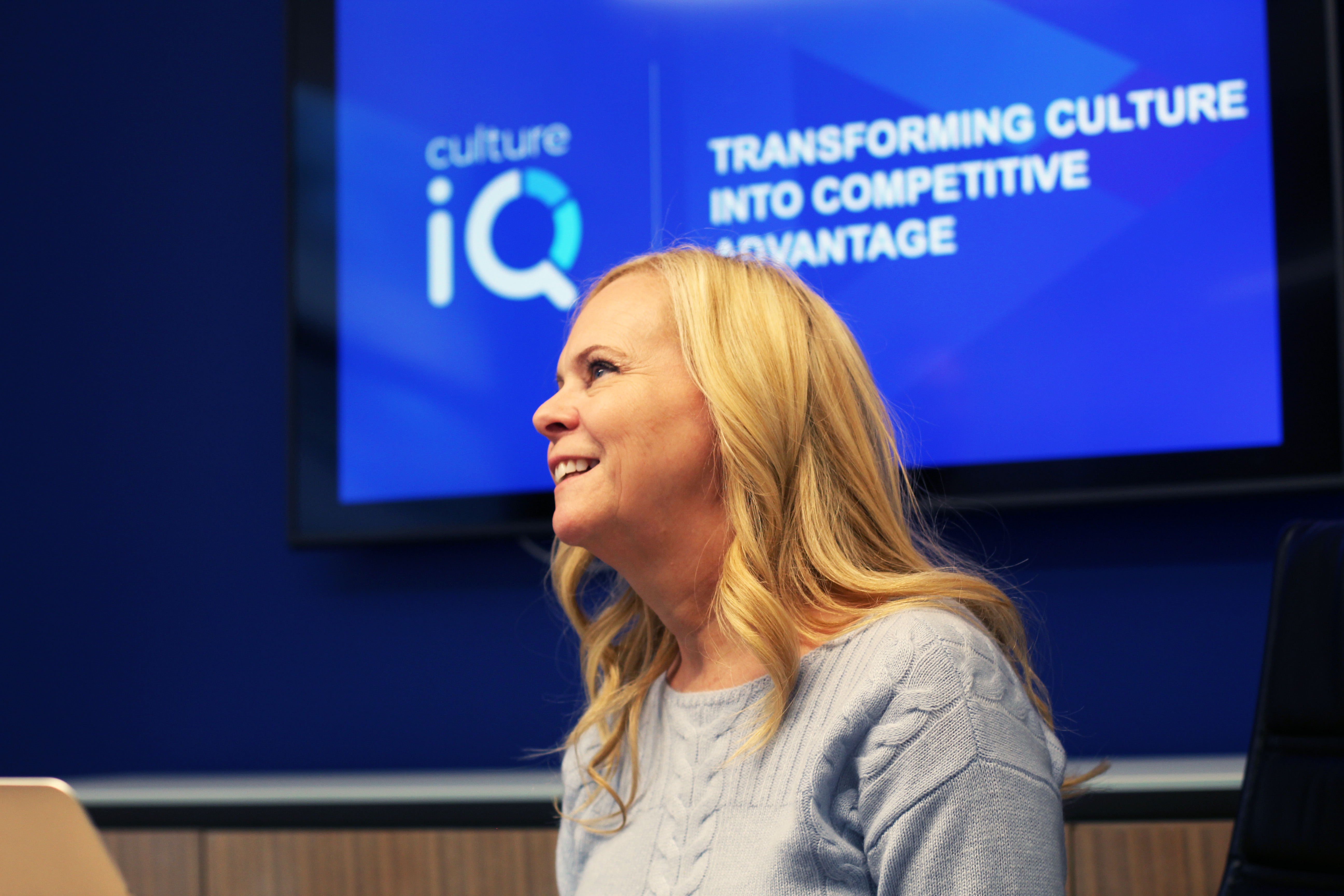 Sheridan Orr in conversation at CultureIQ, with a screen about transforming culture behind her