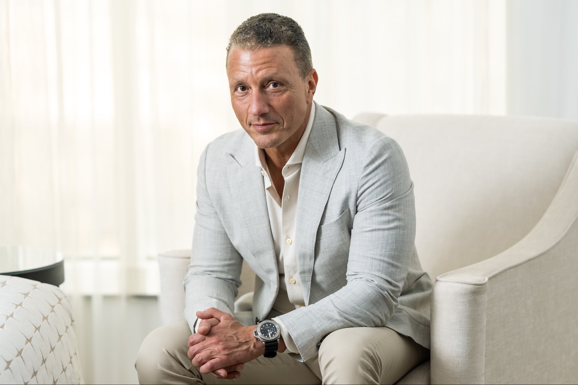 Sherif Foda seated for a press portrait in a light grey jacket