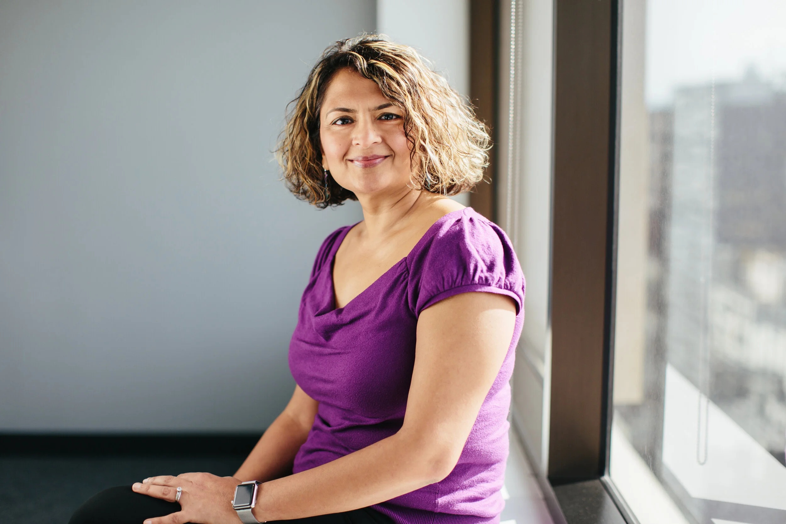 SheTO co-founder Nidhi Gupta seated beside a window