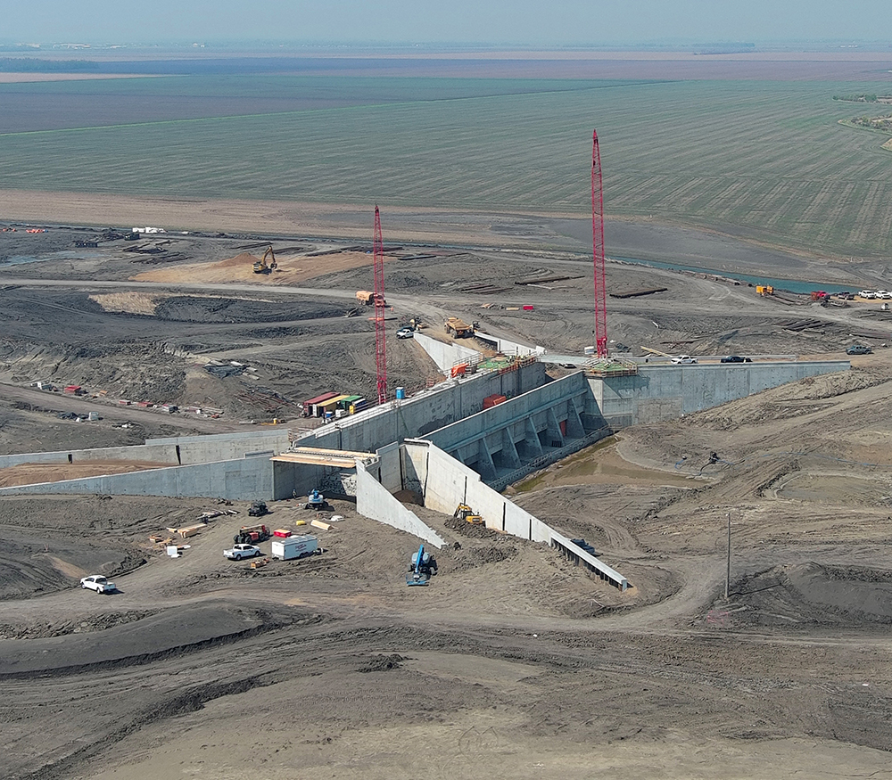 Concrete aqueduct structures under construction amid the flat farmland of the Fargo-Moorhead diversion project