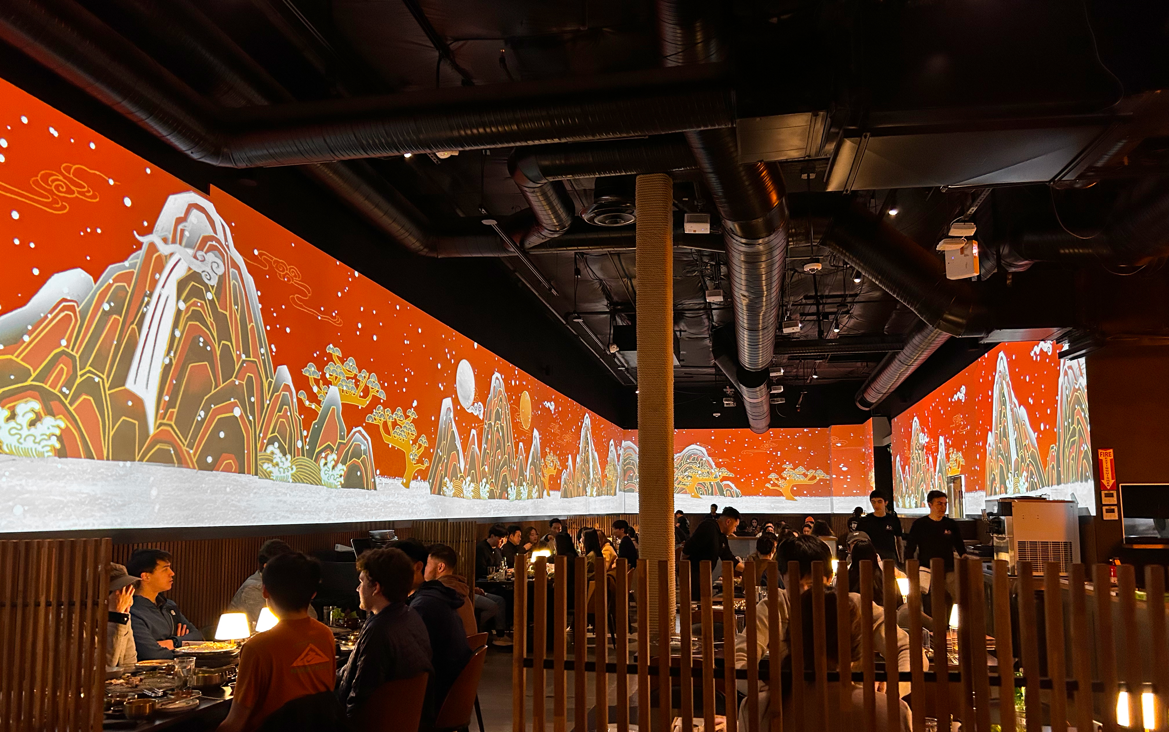 The dining room at OLHSO House in San Mateo with illuminated Korean landscape projections