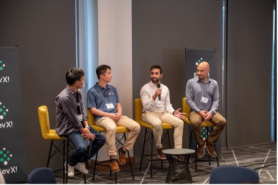 Four participants discussing NEC X alumni startups at the FutureFusion Forum