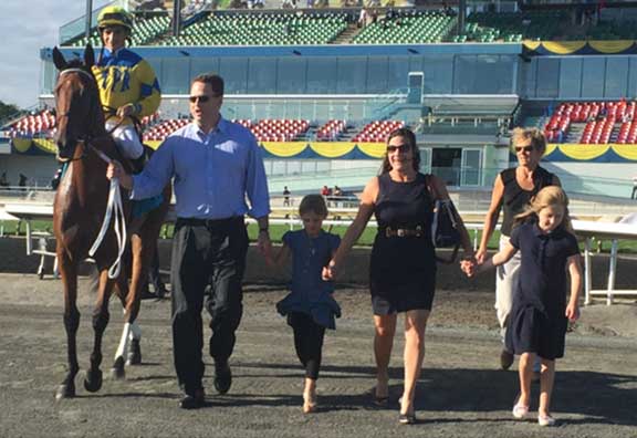 Shirl Penney, Mary Ann and their daughters walking beside Flipcup at the racetrack