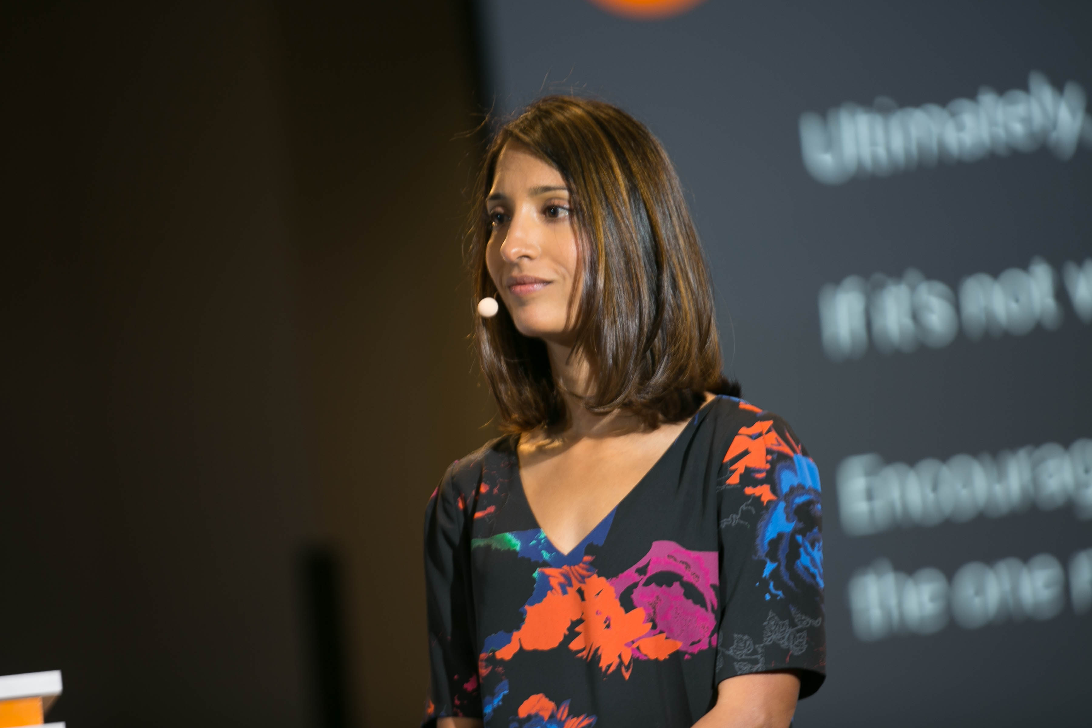 Shivani Siroya speaking onstage in a floral dress at Launch Scale
