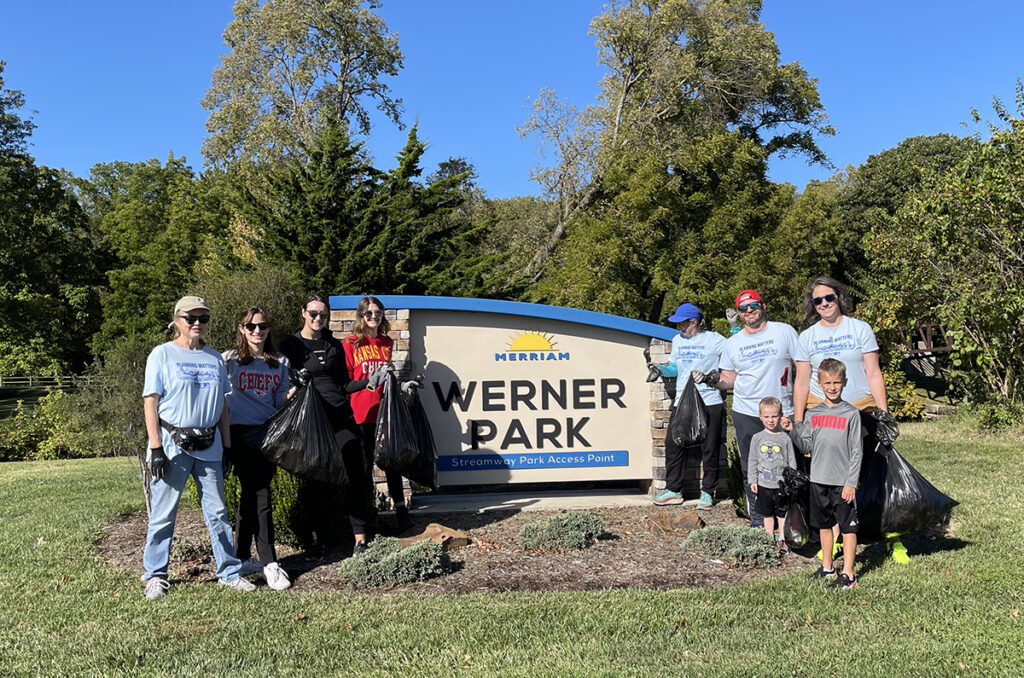 Shockey Consulting volunteers holding cleanup bags at Werner Park in Merriam, Kansas