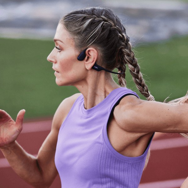 A runner wearing black Shokz OpenRun Pro bone-conduction headphones