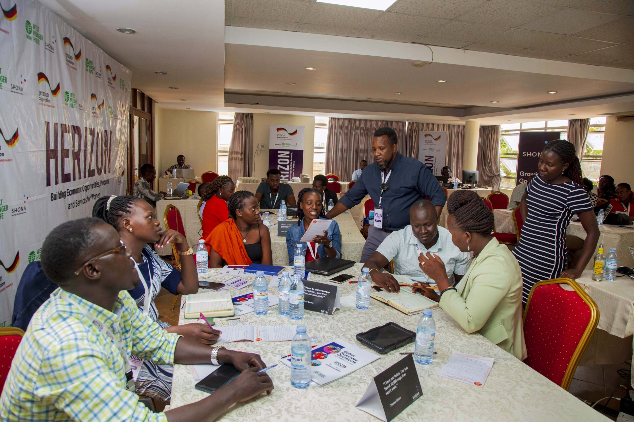 Entrepreneurs and facilitators work around tables during a Herizon program session