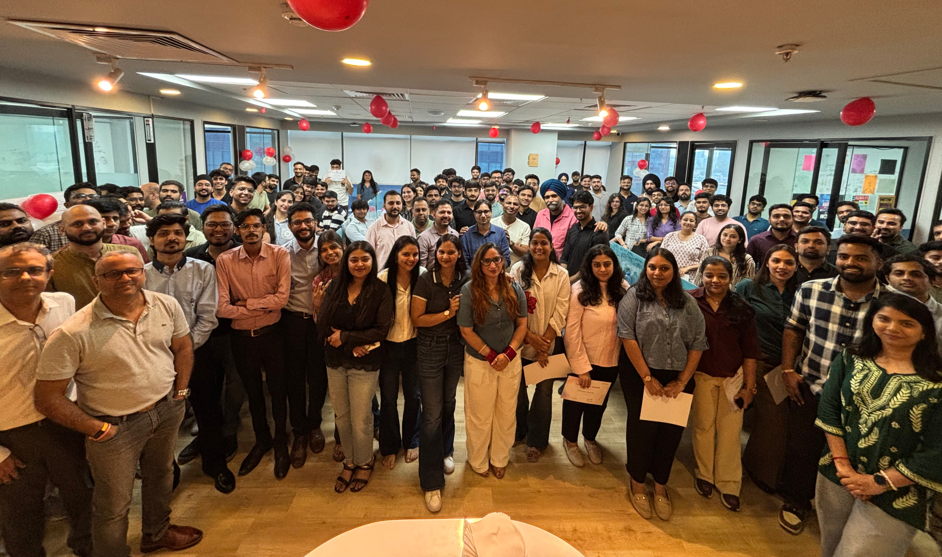 Shorthills AI team gathered in an office with red balloons