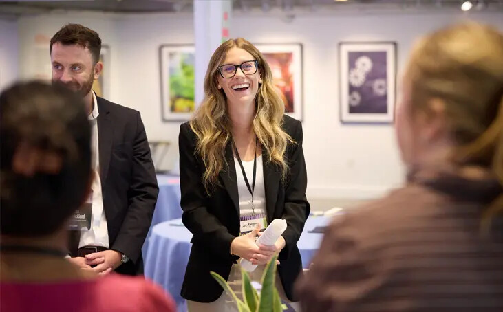 Showpad team members speaking with colleagues at an office gathering