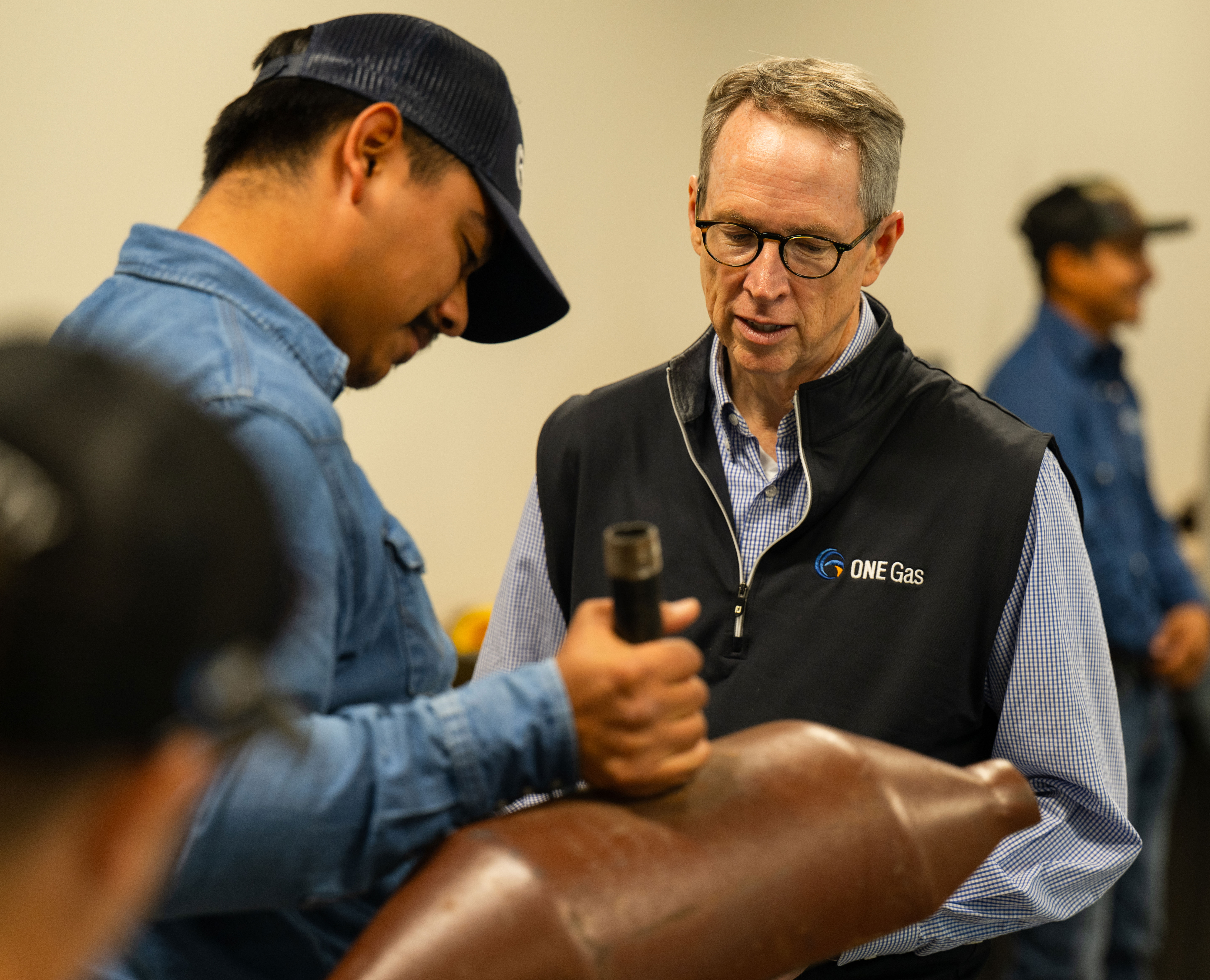 Sid McAnnally watches a training-center employee demonstrate equipment, with other employees nearby.