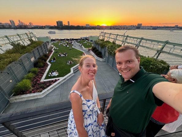 Karen and Sid Sijbrandij taking a selfie near a waterfront park at sunset