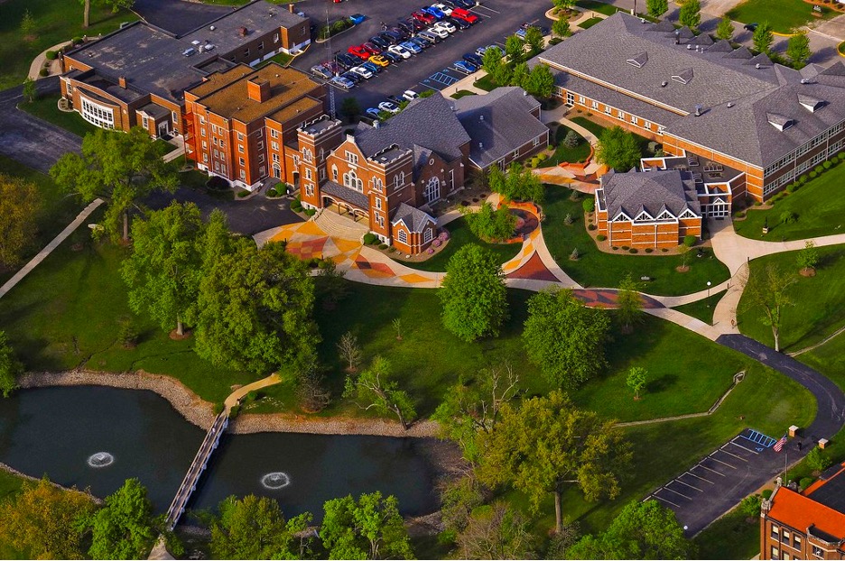 Aerial view of William Woods University, with brick buildings, paths and a pond
