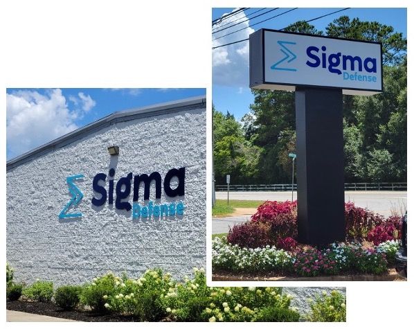 Company photographs showing Sigma Defense signage on its Perry office building and roadside sign.