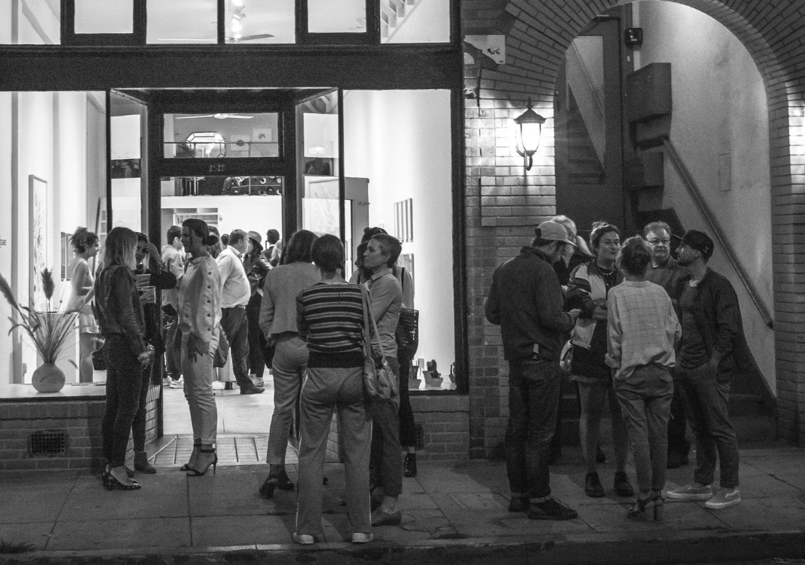 Visitors gathering outside a gallery at night, as pictured on Signature Creative’s About page
